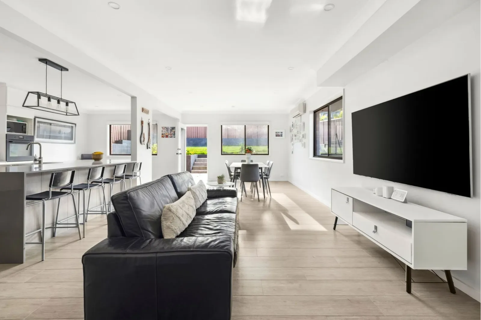 Open-plan home renovation featuring a modern kitchen, dining area, and contemporary living space.